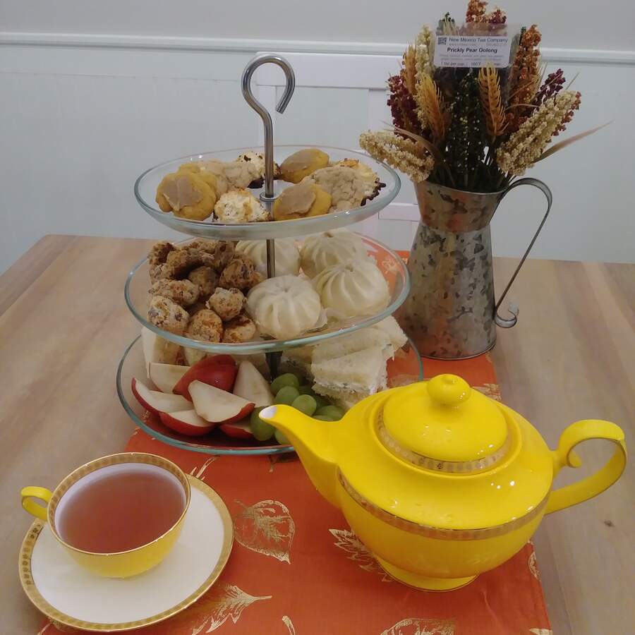 A classic high tea setup with a tiered platter of pastries and cut ...